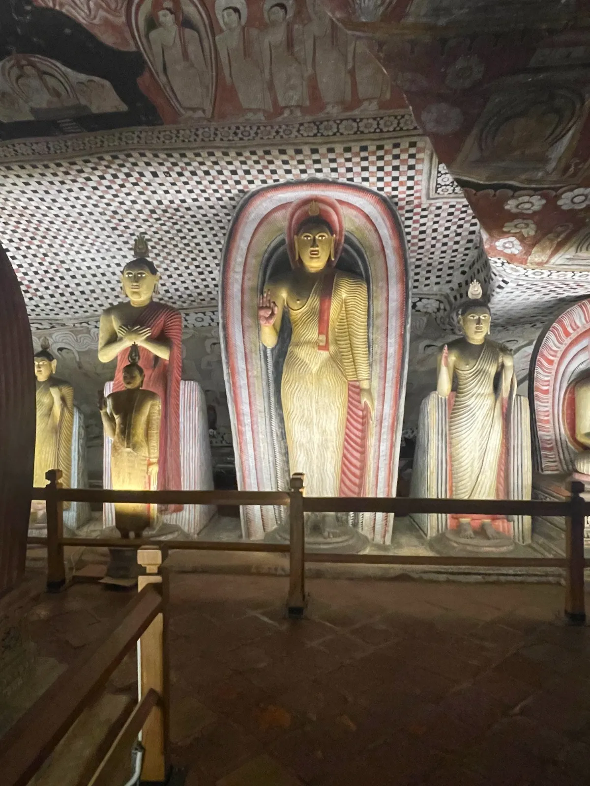 Standing Buddha statues in an arched niche inside the Dambulla caves
